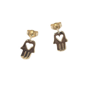 A pair of gold Hamsa hand stud earrings with a heart-shaped cutout, displayed on a clean white background.